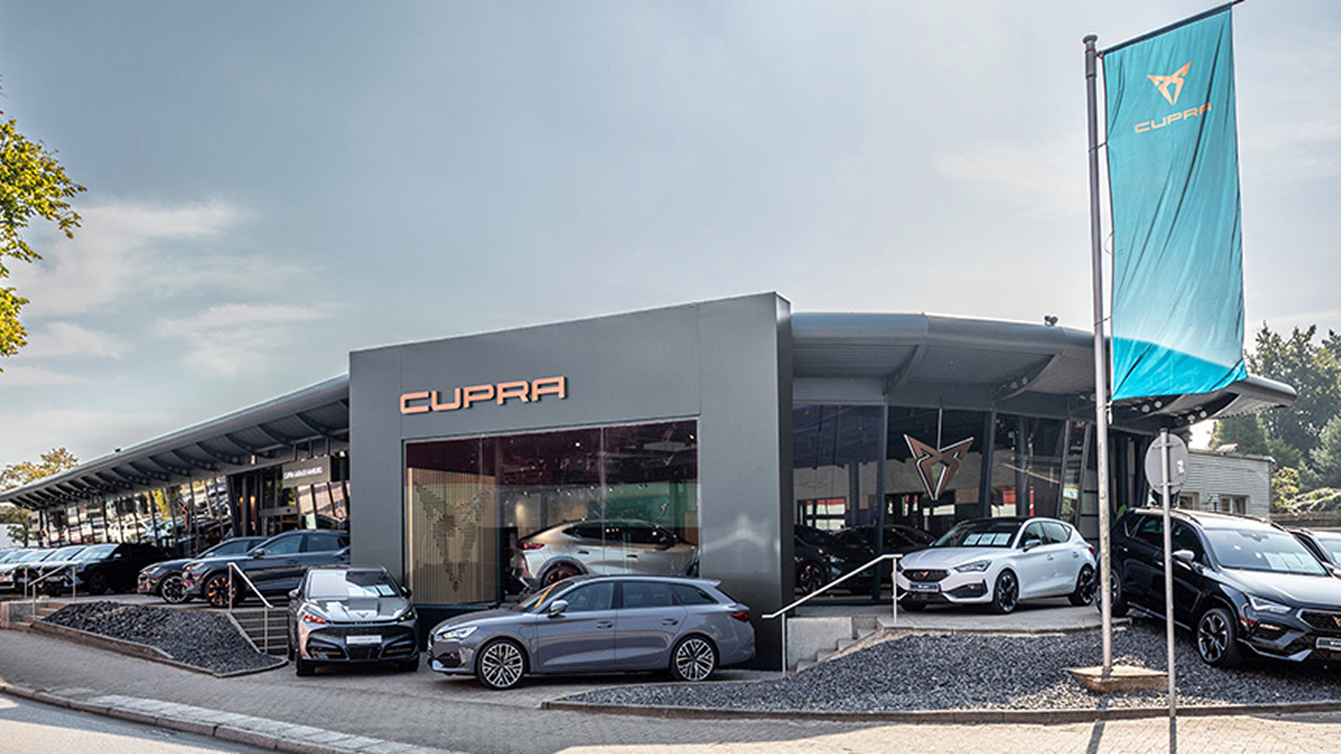 Außenansicht der CUPRA Garage Hamburg mit zwei ausgestellten CUPRA Fahrzeugen vor dem Eingang